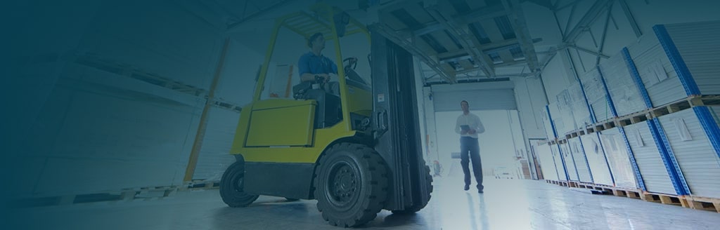 Businessman supervising forklift truck driver