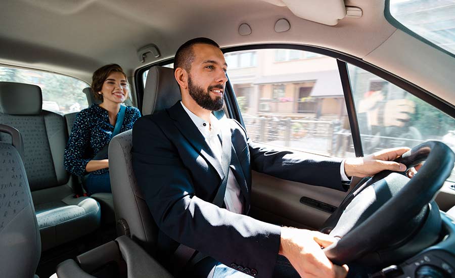 A female passenger in a car with a smiling driver​