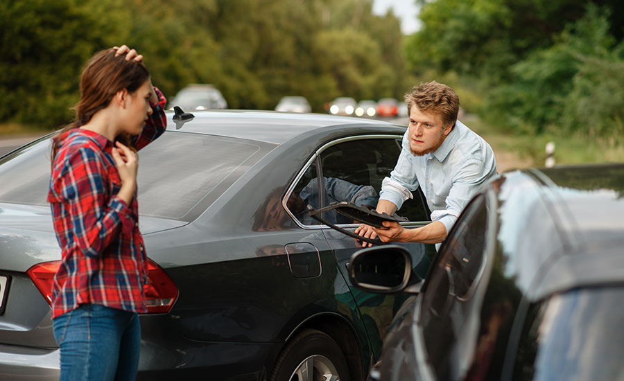 A man and a woman on the road after a car accident​